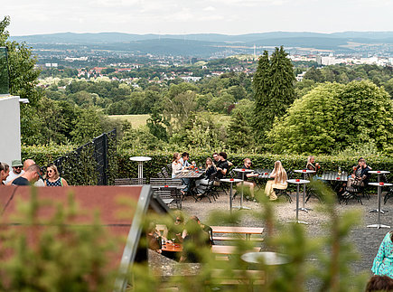 Blick durch Bäume auf Biergarten