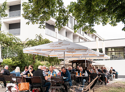 Biergarten mit Hotel im Hintergrund