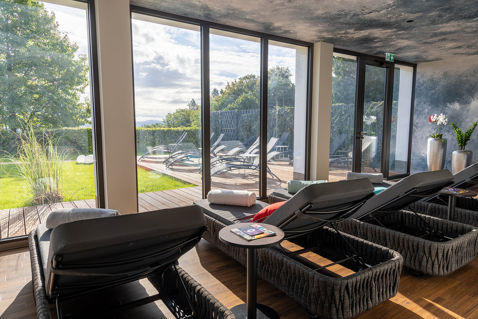 Wellnessliegen mit Blick durch Fensterfront in Garten