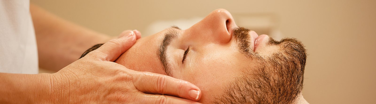 Mann auf Rücken erhält Kopfmassage