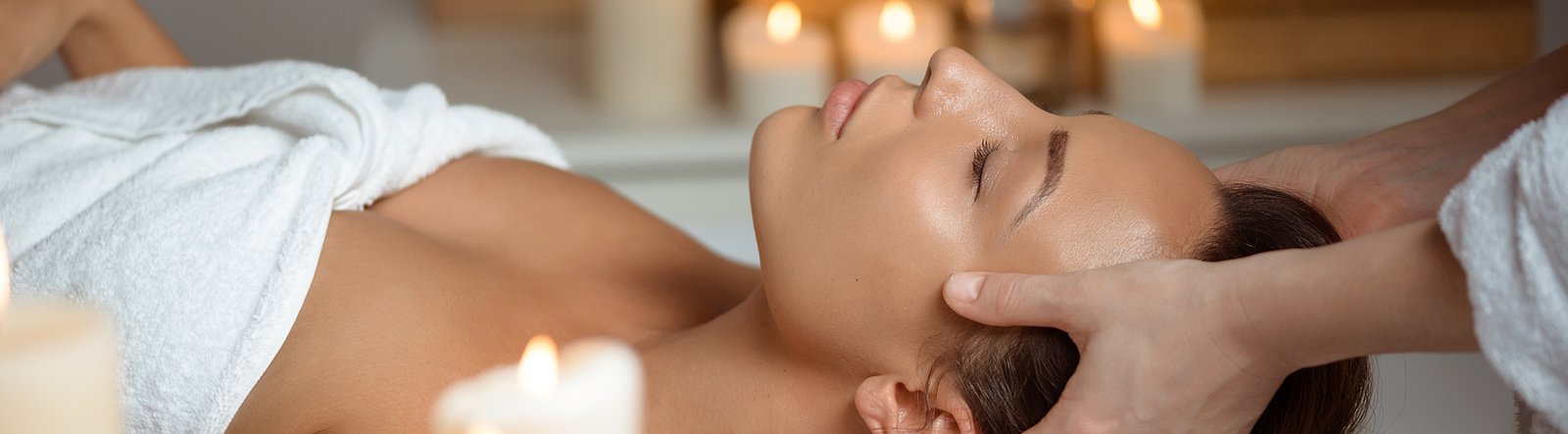 Frau liegt auf Rücken und erhält Kopfmassage